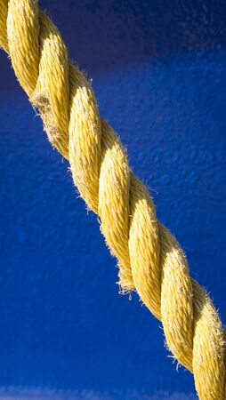 Photo of a yellow rope on blue background.