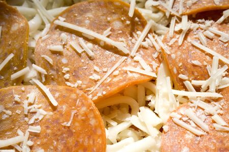 Photo of a sheet of uncooked pepperoni pizza.の写真素材