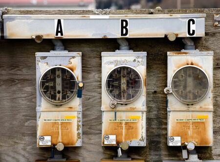 Three empty, weathered electric metersの写真素材