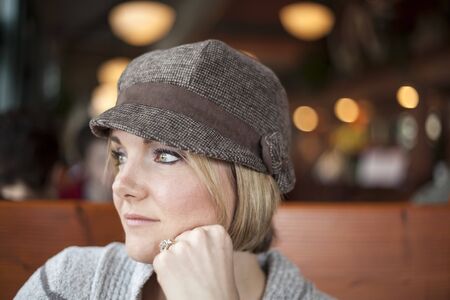 Young woman in cute brown hat staring off into the distance
