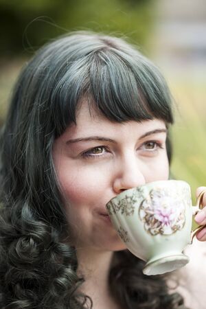 Portrait of a young woman with antique tea cup.の写真素材