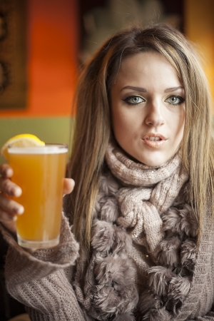 Portrait of a young woman with beautiful blue eyes drinking a pnt of hefeweizen beer.の写真素材