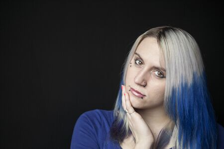 Portrait of a beautiful young woman with blue hair shot on a black background.の写真素材