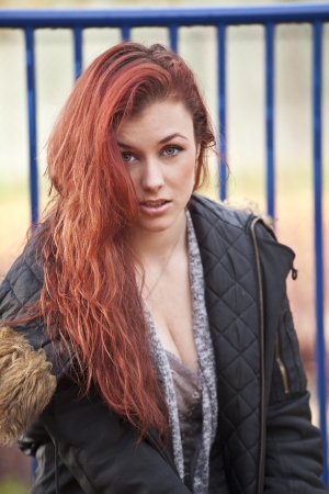 Young woman with beautiful red hair on playground equipment.の写真素材