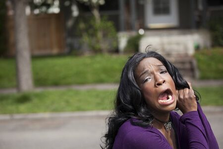 Horrified young African American woman in a purple top.