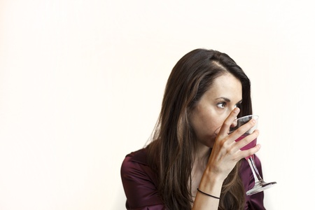 Beautiful young woman with brown hair and eyes holding a pink martini.