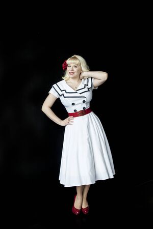 Portrait of a beautiful young woman with blond hair and brown eyes iin a cute white sailor dress.の写真素材