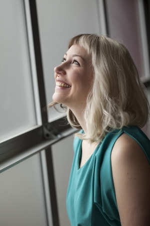 Portrait of a beautiful young woman with brown and blond hair looking up and smiling.の写真素材