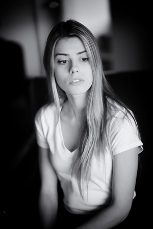 Black and white photo of a very attractive blonde woman with beautiful brown eyes in a white top.の写真素材