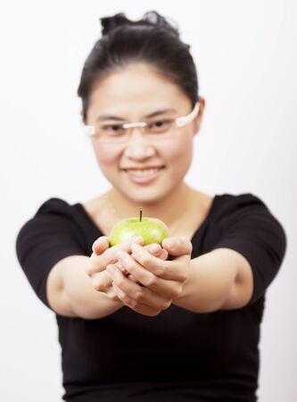 Asian woman holding a green apple.の写真素材