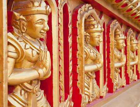 Thai statues on the temple wall 
