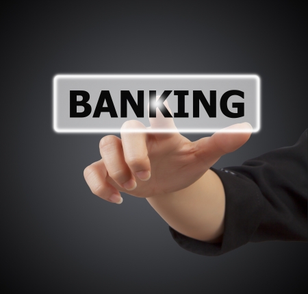 woman hand touching button banking keyword, on gray backgroundの写真素材