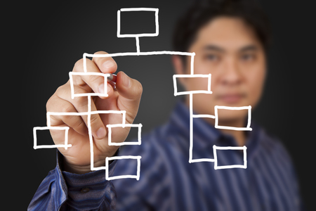 Businessman drawing a chart on gray backgroundの写真素材