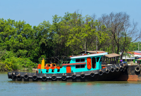 Green small ship at dockの写真素材