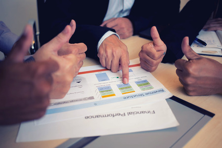 Business people working in the office room and thump up to financial reports reading information to boss background texture concept.の写真素材