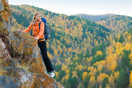 Beautiful young woman on mountain top in autumnの写真素材