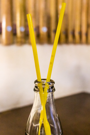 A close up photo of an empty soda bottle with a pair of drinking pipes.の写真素材