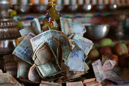 Buddhist altar in India with money donations.の写真素材