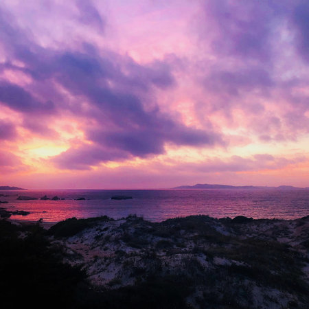 Dramatic Sunset over Rocky Coastの写真素材