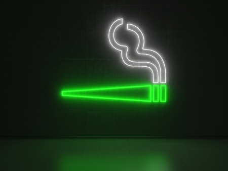 A green and white Neon Sign in Form of a Cigarette on a Wall of Concreteの写真素材