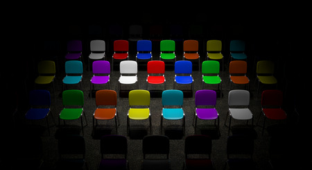 A grid of multicolored chairs bright illuminated fading in dark backgroundの写真素材