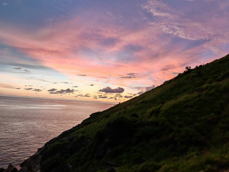 Sunset Sky over Ocean and Green Hillsideの写真素材