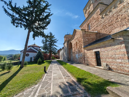 Monastery stone church with pathway and trees