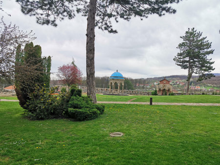 Green lawn with trees and blue dome pavilion in distant parkの写真素材