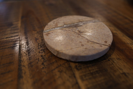 Round stone coaster on wooden tableの写真素材