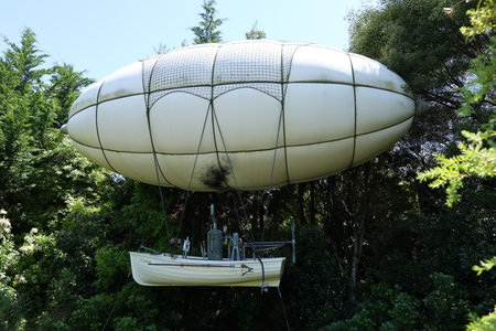 Airship with boat above forest