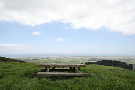 Rustic Picnic Bench Overlooking Coastal Farmland Valleyの写真素材