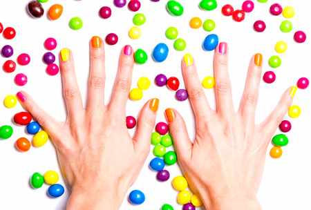 Women s hands with bright candies aroundの写真素材