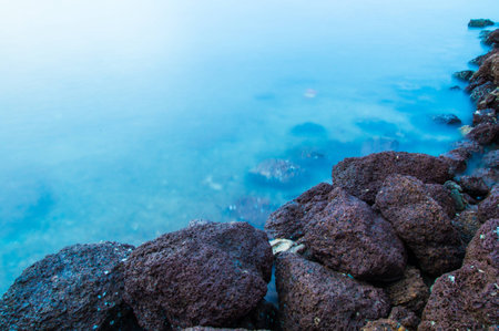 Seaside rocks with beautiful clear blue waterの写真素材