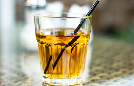 Apple juice with a straw is on the tableの写真素材