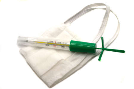 coronavirus background. White medical mask and thermometer on white Face mask protection against...