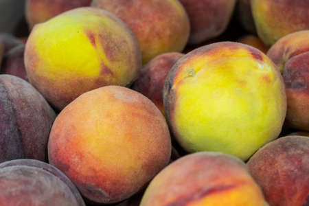 A group of ripe peaches in a bowlの写真素材