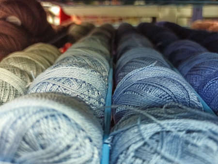 Set of colored threads for sewing on coils. Pile of big colorful spools of thread. Colored thread...