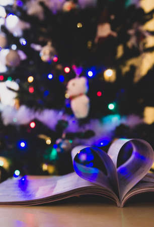 heart shape from paper book with christmas tree in the backgroundの写真素材