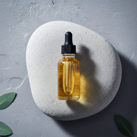 Essential oil in a glass bottle on a gray stone background.の素材