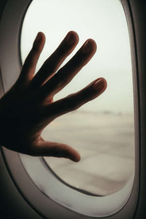 hand on an aeroplane windowの写真素材