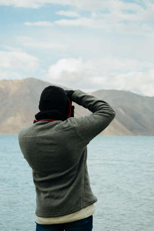 A photographer photographing Pangong Lake, Ladakh, Indiaの写真素材