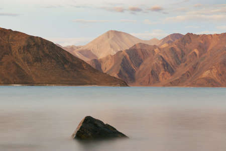 Long Exposure Landscape photo of Pangong Lake with arid mountains at sunset in Ladakh, Indiaの写真素材