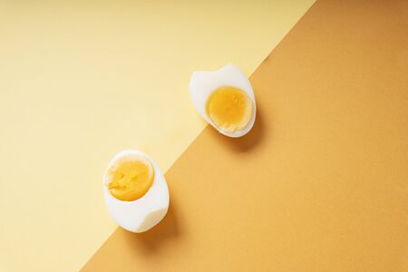 Top view - Boiled eggs slice over yellow and brown background.の写真素材