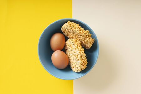Top view - Instant noodles and egg inside the bowl over colourful background.の写真素材