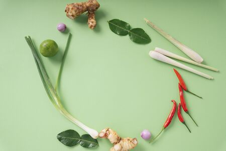 Top view - Spicy Tom Yum ingredients over green background. Thai food.の写真素材