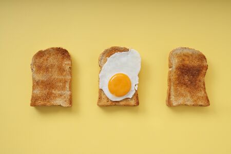Three home made organic sliced bread grill with fried egg on top.の写真素材