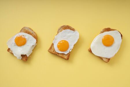 Three home made organic sliced bread grill with fried egg on top.の写真素材