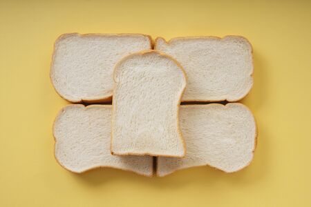 Top view - Home made organic sliced bread over yellow background.の写真素材