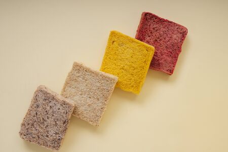 Colourful sliced of bread over yellow background.