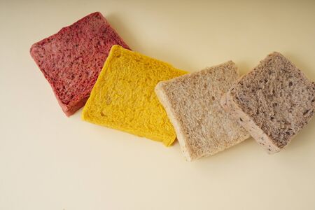 Colourful sliced of bread over yellow background.